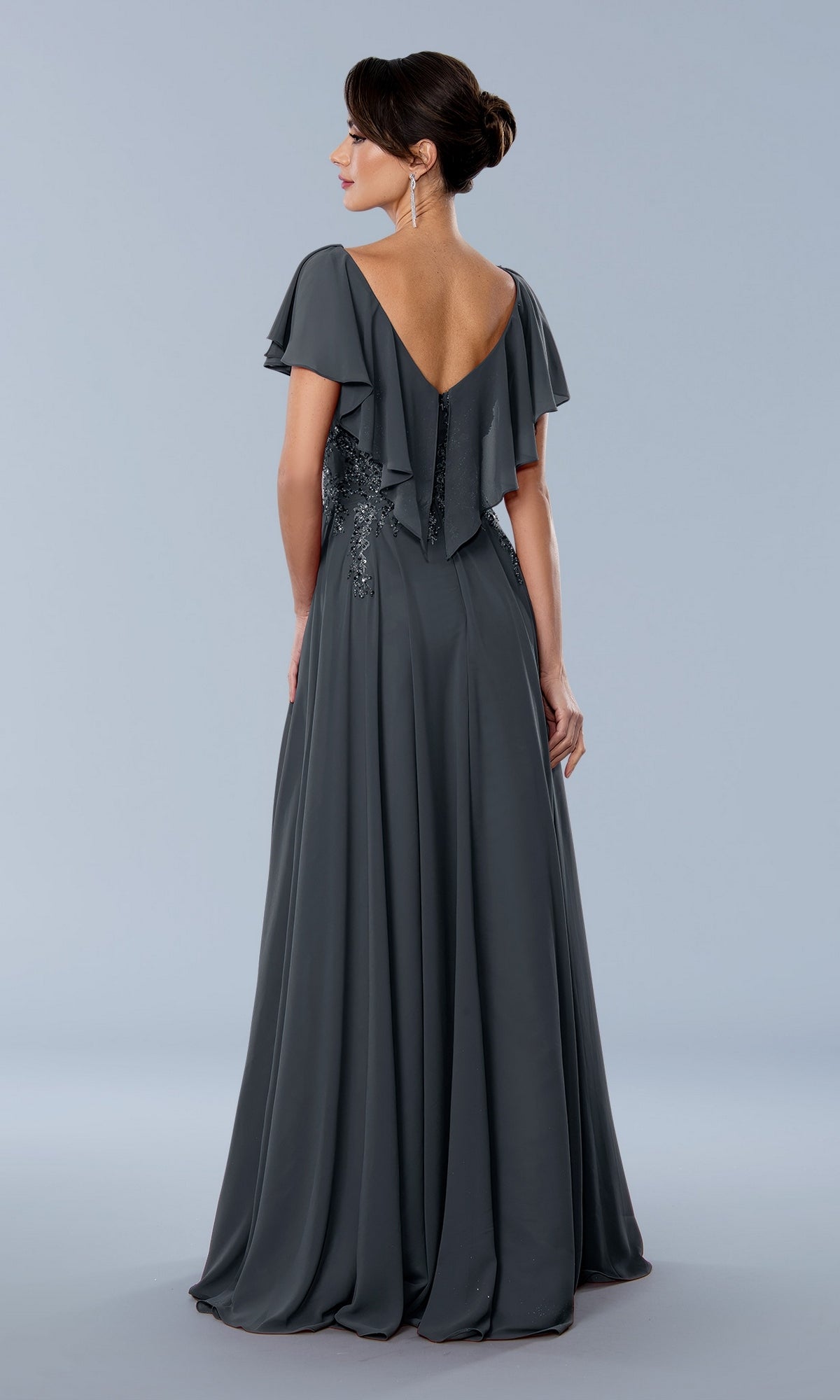 Stella Couture 24352 charcoal grey floor-length gown with a V-back, flutter sleeves, and sequin waist detailing accented with beaded lace appliques.