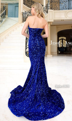 A woman in the Strapless Long Prom Dress: Jessica Angel 2438 stands indoors with her back to the camera, near a staircase featuring ornate railings.