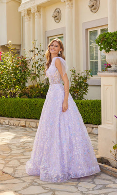 A woman in the Lilac Purple Long Lace Prom Dress Juliet JT2439K, featuring floral patterns, stands smiling on a stone path outside a classical-style building.