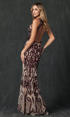 A woman poses in the Juliet 243 Long Prom Dress, a form-fitting, floor-length gown with burgundy velvet patterns on nude mesh and an open back, set against a dark textured background.