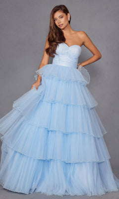A woman models the Strapless Blue Prom Ball Gown: Juliet JT2452K—a tiered, light blue tulle dress—posing against a plain gray background.