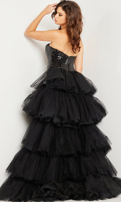 A woman poses in the Jovani Strapless Long Sequin Prom Dress 24554, featuring a strapless neckline and layered tulle ruffles, with her back slightly turned and one hand touching her hair.
