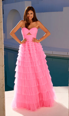 A woman stands by a pool wearing the Long Prom Dress JT2456H by Juliet—a strapless, floor-length pink ball gown with ruffle tulle and a bodice cutout. She smiles confidently with her hands on her hips.
