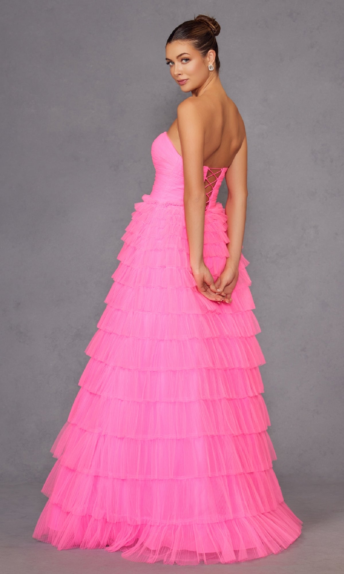 A woman in the Long Prom Dress JT2456H by Juliet, featuring a pink empire waist design.