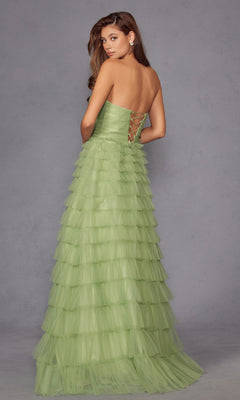 A woman stands against a plain gray background, facing away and looking over her shoulder, wearing the Long Prom Dress JT2456H by Juliet—a strapless ball gown with light green ruffle tulle and an empire waist.