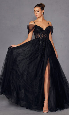 A woman models the Juliet JT2466A Sheer-Waist Long Prom Ball Gown, featuring a black off-the-shoulder design with a sheer bodice, thigh-high slit, and spaghetti straps, standing against a gray background.