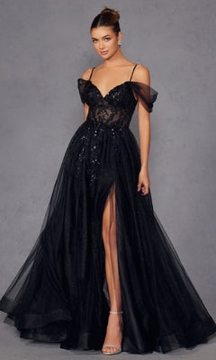 A woman wears the Sheer-Waist Long Prom Ball Gown Juliet JT2466A, featuring a black off-the-shoulder design with sequin details, sheer tulle skirt, and high slit, standing against a plain gray background.