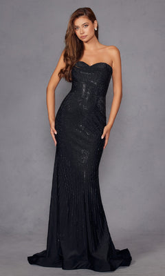 A woman stands against a plain gray background wearing the Strapless Long Sequin Prom Dress Juliet JT2472R—a fitted, floor-length black gown with subtle shimmering details.