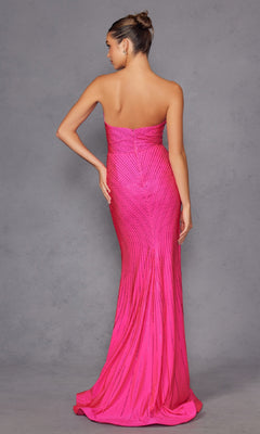 A woman stands with her back to the camera against a plain gray background, wearing the Juliet JT2472R Strapless Long Sequin Prom Dress featuring a fitted, floor-length pink silhouette with subtle vertical detailing.