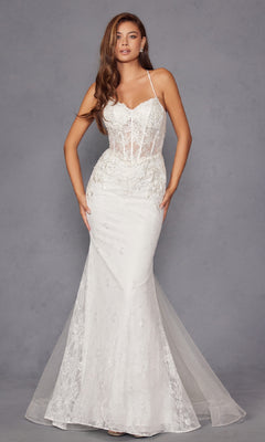 A woman wears the Long White Bridal Dress: Juliet JT2481UW, a fitted off-white gown with thin straps, sheer corset bodice, and floral lace embroidery, standing against a plain gray background.