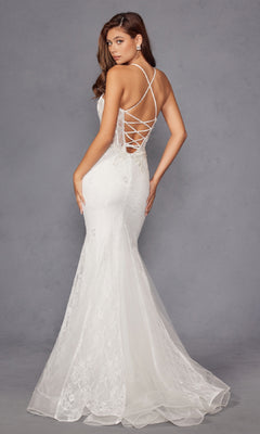 A woman stands against a neutral gray background wearing the Long White Bridal Dress: Juliet JT2481UW, featuring an off-white lace design with a flared hem, sheer corset bodice, and floral lace embroidery.