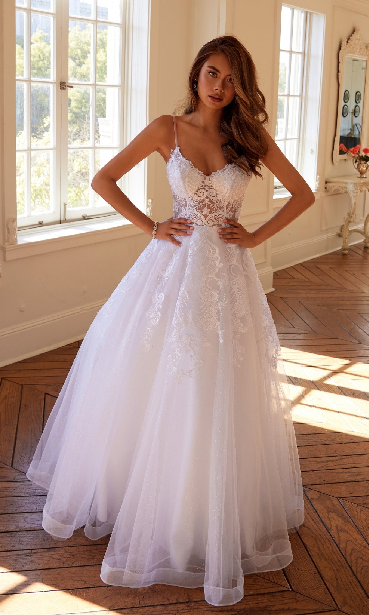A woman in the Long Off-White Prom Dress Juliet JT2482SW, featuring a delicate lace bodice and a flowing tulle A-line skirt.
