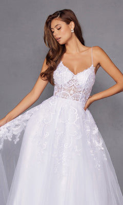 A woman in the Long Off-White Prom Dress: Juliet JT2482SW with thin straps and a lace bodice stands against a gray background, gracefully holding one side of her skirt.