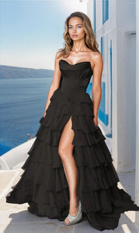 A woman in a black strapless long ruffled prom ball gown with a sweetheart neckline and a side slit.