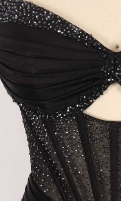 Close-up of the rhinestone detailing on the sheer corset bodice of a black dress.
