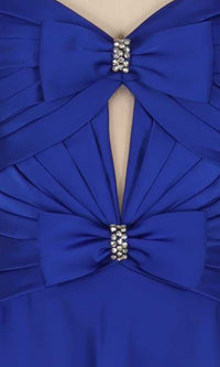 Close-up of the details on a blue dress including two bows with rhinestone embellishments, pleating, and a cut out.