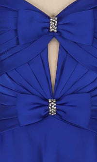 Close-up of the details on a blue dress including two bows with rhinestone embellishments, pleating, and a cut out.