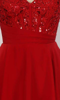 Close-up of red dress with sequin embroidered embellishments on a plain background