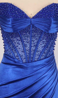 Close-up of a royal blue dress with pearl embellishments on a sheer corset bodice