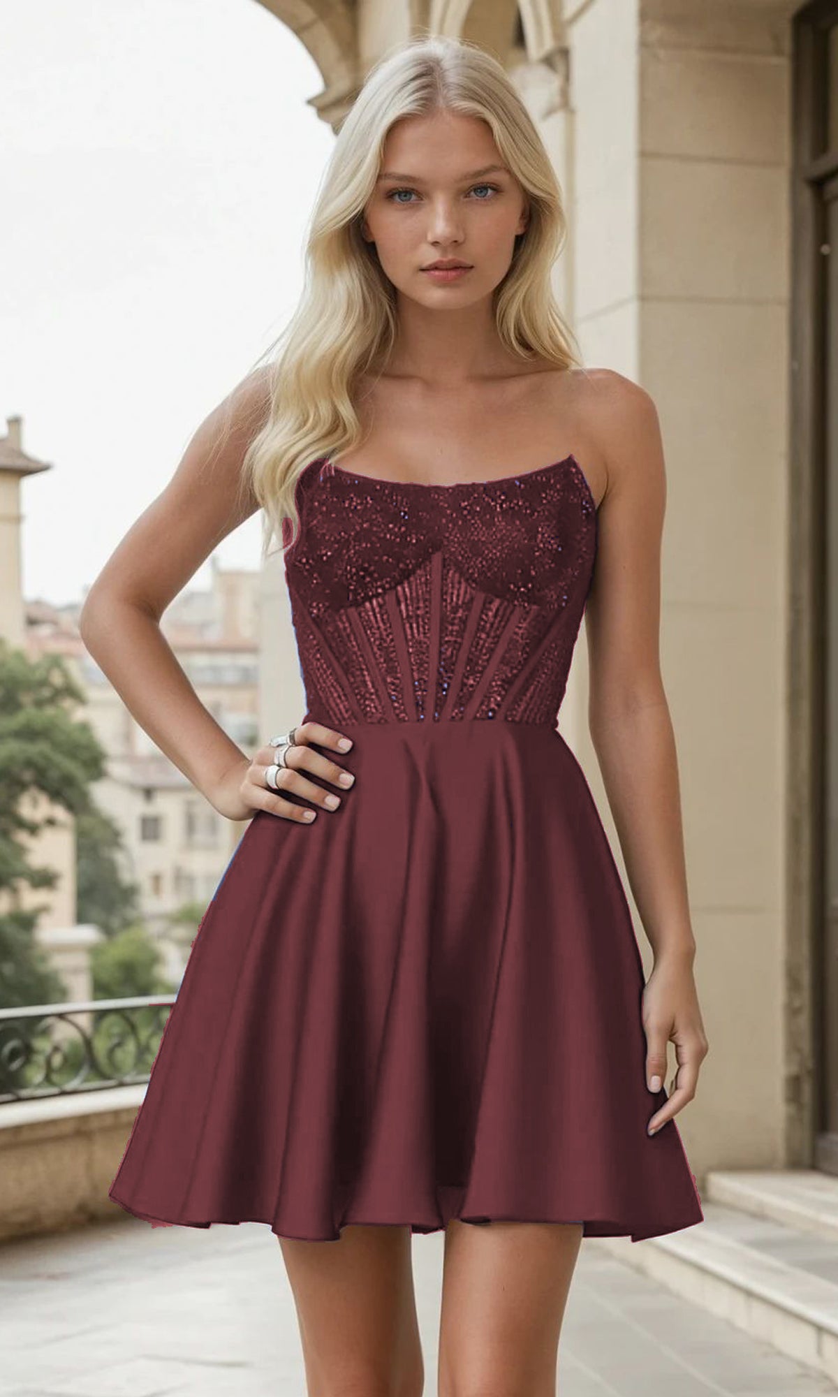 Woman wearing a burgundy strapless short dress with sequin details in an urban setting
