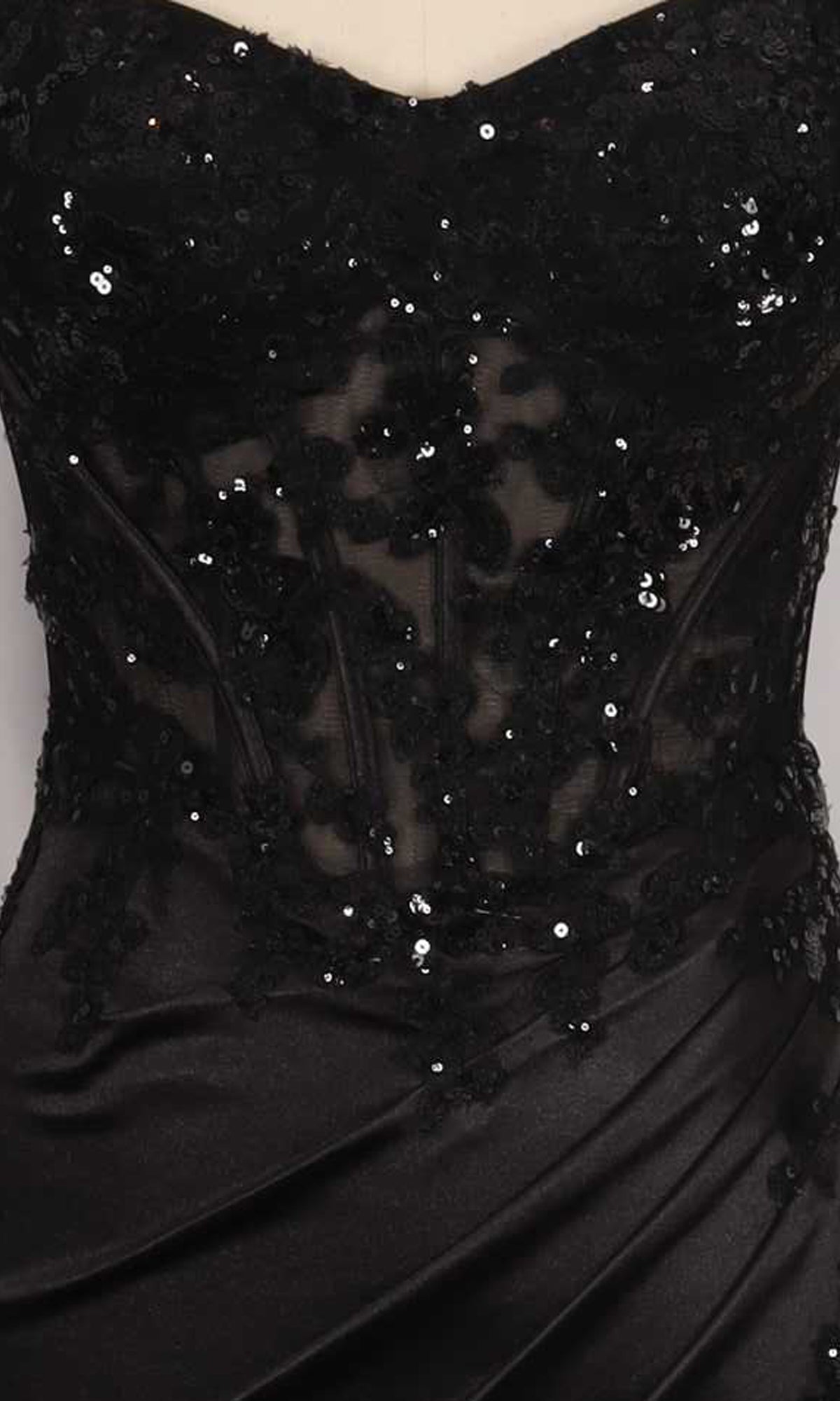 Close-up of a black dress with sequin detailing on a sheer corset bodice.
