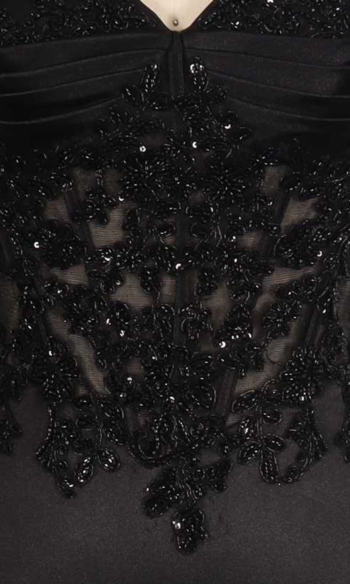 Close-up of a black beaded dress on a mannequin.