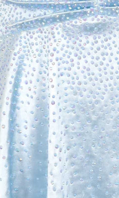 Close-up of a light blue dress fabric swatch with heat-set stone embellishments.