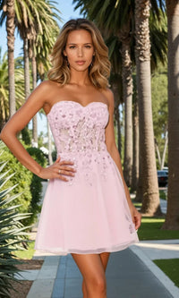 Woman in a pink strapless dress standing outdoors with palm trees in the background