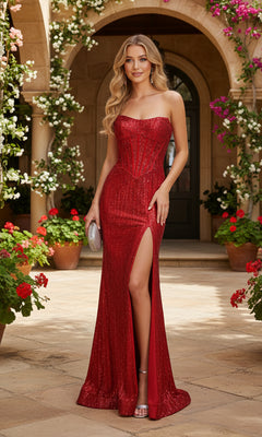 A woman wearing the red PromGirl Exclusive 250234 long prom dress with linear beading and a thigh-high slit stands outdoors among potted flowers, holding a silver clutch.