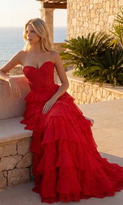 Wearing the Chiffon and Lace Prom Gown: PromGirl Exclusive 250238, a woman sits on a stone bench outdoors, encircled by stone walls and lush greenery.