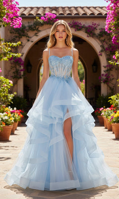 A woman wearing the Long Prom Dress: PromGirl Exclusive 250241, a light blue gown with ruffles and a beaded corset-style bodice, stands outdoors before a flower-adorned archway.