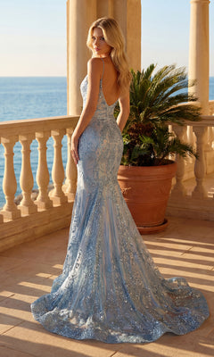 A woman in the Fit-and-Flare Prom Dress: PromGirl Exclusive 250249 stands on a balcony overlooking the sea, with a potted palm behind her.