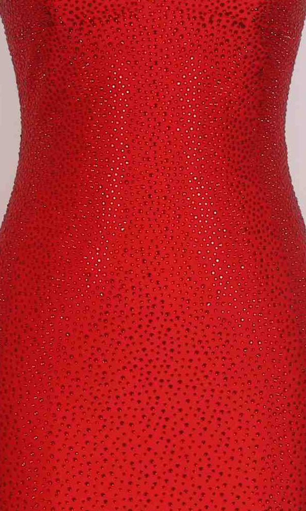 Close-up of the PromGirl Exclusive 250298, a red long prom dress featuring an open back, a fitted waistline, and numerous small, shiny heat stone embellishments.