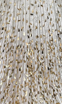 Close-up of the white fabric on the Sparkly Sequin Prom Dress: PromGirl Exclusive 250304, showing vertical sequin rows and metallic gold accents that create a shimmering, textured look.
