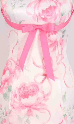 Close-up of the PromGirl Exclusive 250333: a long white prom dress with pink floral prints, featuring a pink ribbon bow at the waist.