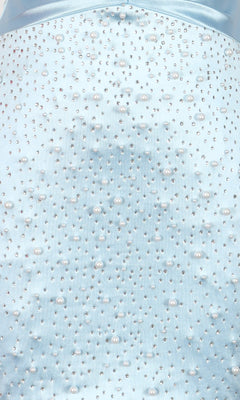 Close-up of light blue fabric from the PromGirl Exclusive 250345 short homecoming dress, featuring small beads and pearls in a scattered pattern.