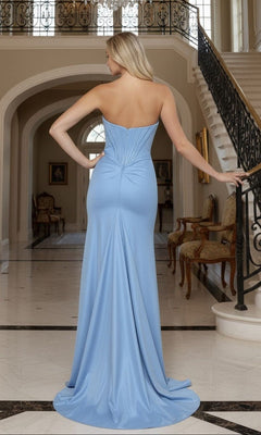 A woman wearing the Long Prom Dress: Poly USA 25054, featuring a strapless corset bodice, stands with her back to the camera in an elegant marble interior with grand staircases and ornate chairs.