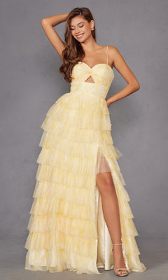 A woman wears the Juliet JT2508A Long Yellow Ruffled Prom Dress, featuring a pastel yellow hue, sweetheart neckline, cutout detail, spaghetti straps, thigh-high slit, and tiered tulle A-line skirt against a gray background.