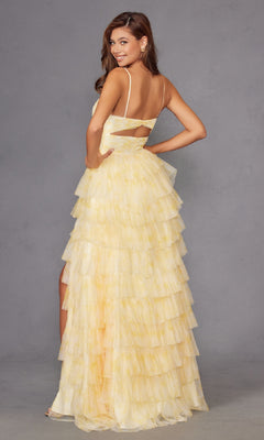 A woman poses confidently with one hand on her hip in the Long Yellow Ruffled Prom Dress: Juliet JT2508A, featuring thin straps, an open back, and a side slit, set against a plain gray background.