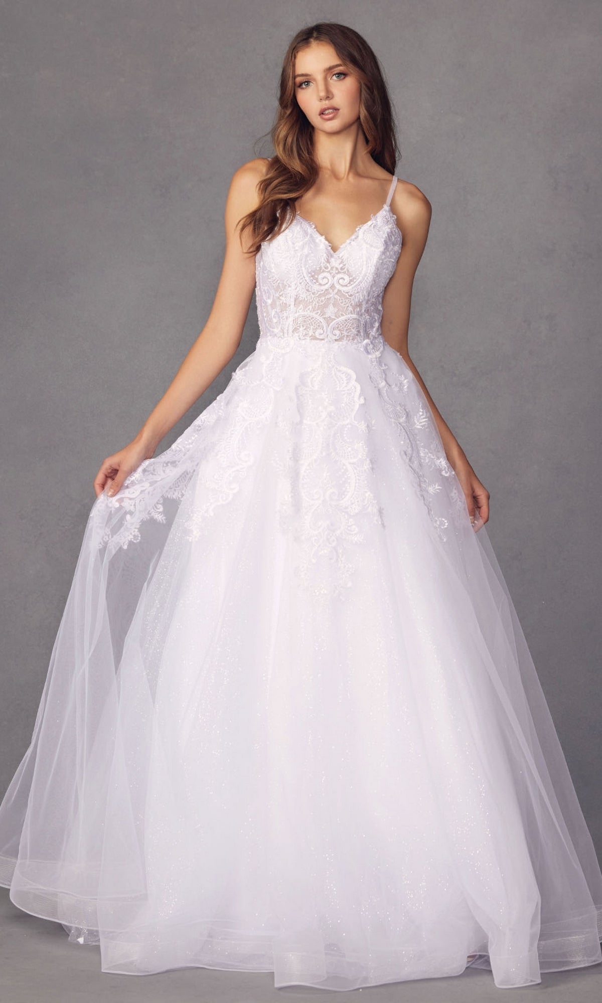 A woman models the Embroidered Glitter-Tulle Long Prom Ball Gown 251, a white sleeveless dress with a fitted bodice, thin straps, and a full tulle skirt, against a plain gray background.