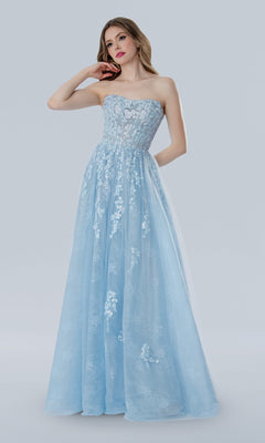 A woman stands against a plain light gray background wearing the Stella Couture 25108, a long strapless light blue prom dress with delicate floral lace embroidery.