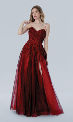 A woman in the Stella Couture 25109 long prom dress—sleeveless, floor-length red lace with floral embroidery and a thigh-high slit—stands against a plain light background.