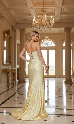 A woman in the Poly USA 25154 long prom dress stands in an ornate, marble-floored hall with chandeliers and tall windows. The strapless satin gown features sparkling rhinestone embellishments.