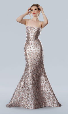 A woman stands against a plain light gray background wearing the Stella Couture 25328 long formal dress in rose, a floor-length, form-fitting evening gown with a metallic floral pattern.