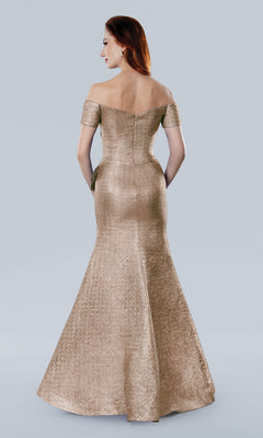A woman faces away from the camera in a rose Stella Couture 25331 long formal dress, its off-the-shoulder, floor-length fitted silhouette subtly shimmering under the light against a plain backdrop.