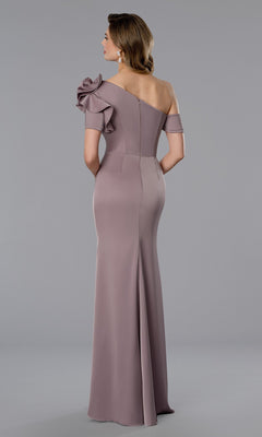 A woman stands with her back to the camera against a plain gray background, wearing the Stella Couture 25360 long mauve formal dress featuring off-the-shoulder sleeves and a large ruffle detail.