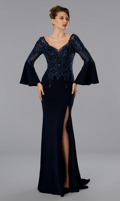 A woman stands against a gray background wearing the Stella Couture 25366 long formal dress in navy, featuring lace detailing, bell sleeves, a V-neckline, beaded bodice, and a thigh-high slit.