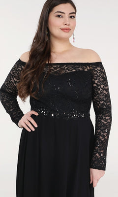 A woman poses with one hand on her hip in a Long A-Line Lace-Bodice Plus-Size Formal Dress, featuring long sleeves and an elegant off-the-shoulder black lace bodice against a plain background.