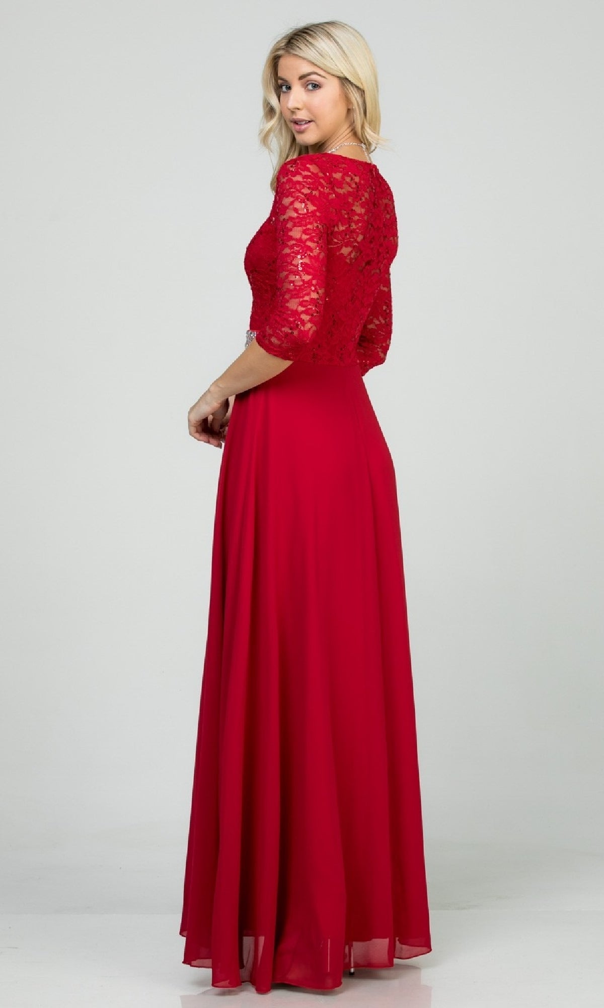 Woman wearing the Sleeved V-Neck Long A-Line Formal Dress 25434, featuring lace sleeves, a lace bodice, and a rhinestone-embellished waistline, stands against a plain background looking over her shoulder.