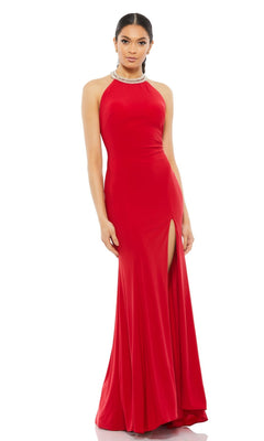 A woman stands against a plain white background wearing the Long Formal Dress 25572 by Mac Duggal—a sleeveless, floor-length red halter neck dress with a high neckline and thigh-high slit.